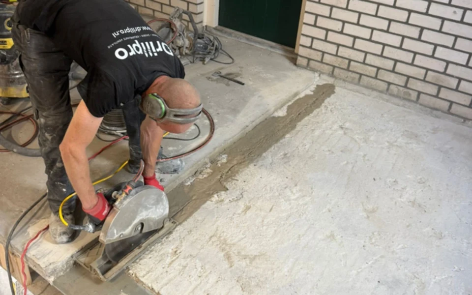 Drillpro-medewerker zaagt een opening in een betonvloer