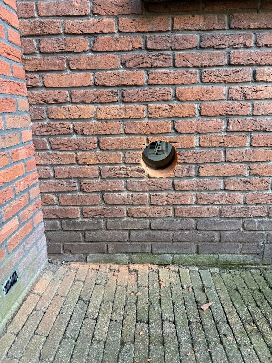 Rond gat door gemetselde buitenmuur