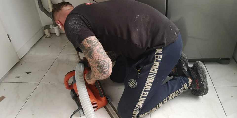 Zaagwerk in een tegelvloer met aangesloten stofafzuiging